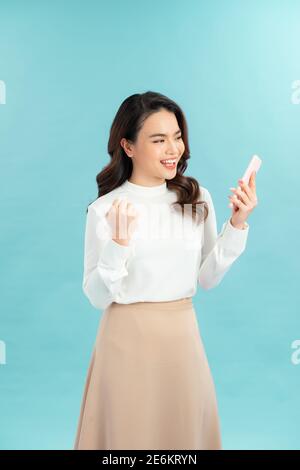 Ritratto foto di giovane bella donna asiatica sentirsi felice o. sorpresa shock e tenere in mano smartphone Foto Stock