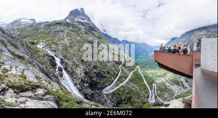 I turisti che si trovano sul punto panoramico Trolls Path si affacciano sul bellissimo valle con passo di montagna Trollstigen in Norvegia Foto Stock