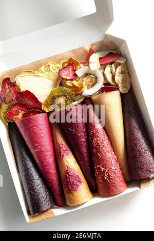 Vista ravvicinata dei coni in pelle di frutta. Nessun cono di cuoio di frutta di zucchero. Cibo sano. Mele, banane, fragole, arance, noci, ribes nero Foto Stock