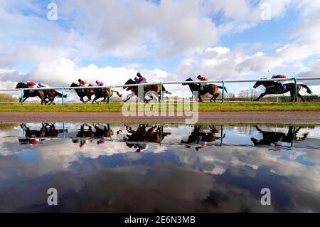 I corridori e i corridori si riflettono in una pozza mentre si trasformano nel diritto durante l'heed il vostro Hunch a Betway handicap all'Ippodromo di Lingfield. Data immagine: Venerdì 29 gennaio 2021. Foto Stock