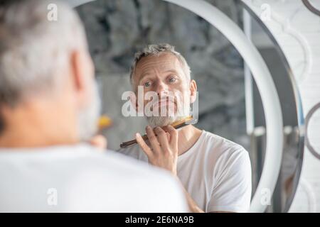 Uomo che pettina la barba con un pettine Foto Stock