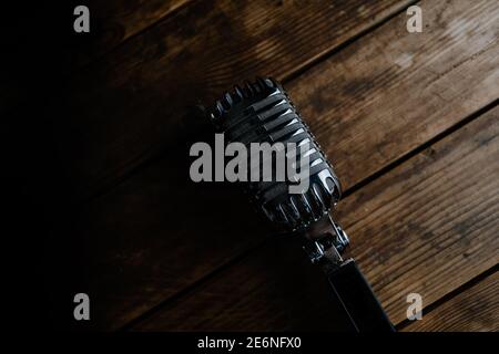 Microfono in stile retrò generico su sfondo di legno scuro Foto Stock