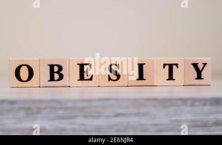 Parola OBESITÀ su blocchi di legno. TESTO della lettera SULL'OBESITÀ scritto su blocchi di legno su tavolo di legno. Foto Stock