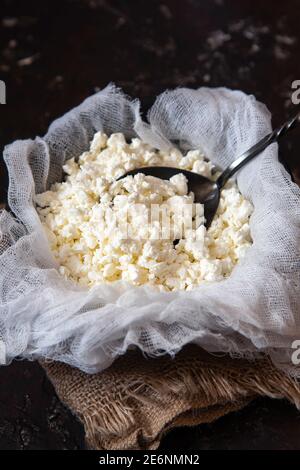 Formaggio fresco casolare su garza su fondo nero. Foto Stock