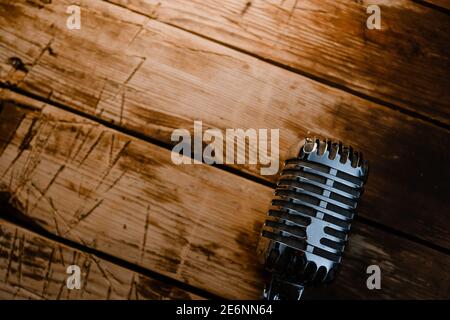 Microfono in stile retrò generico su caldo sfondo di legno con copia spazio per il testo Foto Stock