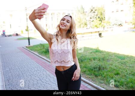 Portrait of a smiling young girl making selfie photo in park Stock Photo