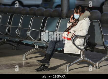 Fuyang, Cina. 29 gennaio 2021. Un passeggero attende al telefono prima di prendere il suo treno alla stazione ferroviaria di Fuyang.mentre la corsa di viaggio del Festival di primavera è iniziata, gli operatori di trasporto hanno inasprito le misure per prevenire la rinascita dei casi COVID-19 (Coronavirus) rendendo la maschera facciale obbligatoria per tutti i passeggeri nella stazione ferroviaria. Secondo il ministero, circa 1.15 miliardi di viaggi di passeggeri avrebbero dovuto essere effettuati durante la corsa di 40 giorni, con un calo annuale del 20% e più del 60% inferiore rispetto al 2019. Credit: SOPA Images Limited/Alamy Live News Foto Stock