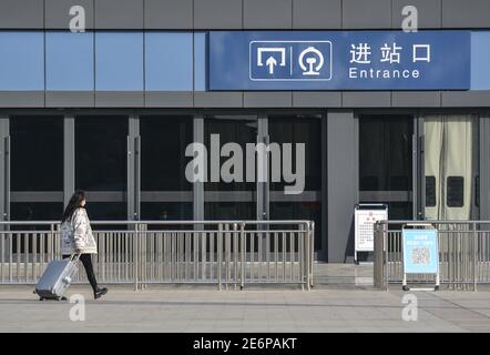 Fuyang, Cina. 29 gennaio 2021. Un passeggero con bagaglio entra nella stazione ferroviaria di Fuyang. Con l'inizio della corsa di primavera del Festival, gli operatori di trasporto hanno stretto misure per prevenire la rinascita dei casi COVID-19 (Coronavirus) rendendo obbligatoria la maschera facciale per tutti i passeggeri nella stazione ferroviaria. Secondo il ministero, circa 1.15 miliardi di viaggi di passeggeri avrebbero dovuto essere effettuati durante la corsa di 40 giorni, con un calo annuale del 20% e più del 60% inferiore rispetto al 2019. Credit: SOPA Images Limited/Alamy Live News Foto Stock