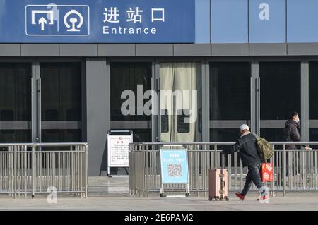 Fuyang, Cina. 29 gennaio 2021. Un passeggero con bagaglio entra nella stazione ferroviaria di Fuyang. Con l'inizio della corsa di primavera del Festival, gli operatori di trasporto hanno stretto misure per prevenire la rinascita dei casi COVID-19 (Coronavirus) rendendo obbligatoria la maschera facciale per tutti i passeggeri nella stazione ferroviaria. Secondo il ministero, circa 1.15 miliardi di viaggi di passeggeri avrebbero dovuto essere effettuati durante la corsa di 40 giorni, con un calo annuale del 20% e più del 60% inferiore rispetto al 2019. Credit: SOPA Images Limited/Alamy Live News Foto Stock