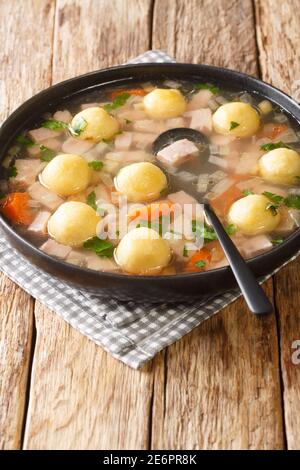 Zuppa di Prati del Liechtenstein e gnocchi di farina di mais closeup nel piatto sul tavolo. Verticale Foto Stock