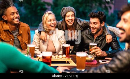 Amici felici che bevono birra al bar della birreria Dehor - amicizia concetto di stile di vita con i giovani milenial che si godono il tempo insieme a. pub all'aperto Foto Stock