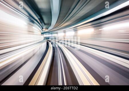 Tunnel sotterraneo della metropolitana con linee ferroviarie sfocate nella galleria della metropolitana - concetto moderno di trasporto pubblico e di collegamento - radiale zoom Foto Stock