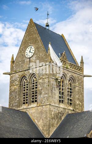 Francia, Manica (50), Cotentin, Sainte-M?re-Eglise, una delle prime città in Francia liberata il 6 giugno 1944, modello del paracadutista americano John Steele (1912-1969) del 505th Parachute Infanteria Reggimento che sbarcò sul campanile della chiesa Foto Stock