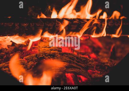 Primo piano di legno in fiamme come sfondo astratto. Le braci calde di fuoco che brucia. Foto Stock