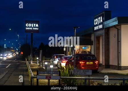 Mansfield Costa coffee drive attraverso negozio silhouette ripresa notturna con i cartelli illuminati sulle vetture che accodano le finestre di attesa illuminate e. negozio aperto in ritardo Foto Stock