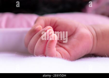 La mano del bambino che riposa su panno pulito e soffice bianco, appena sopportato, 3 settimane fa le ragazze sane della mano del bambino capovolta in su la fotografia, le barrette sono così piccole e l'annuncio Foto Stock