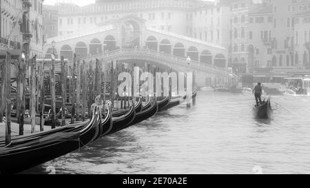 Gondoliere . La gondolatrice Lone naviga lentamente lungo il Canal Grande verso il Ponte di Rialto in una giornata invernale. Foto Stock