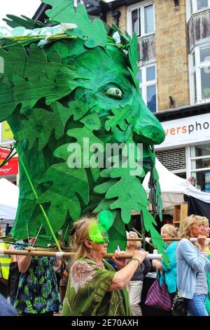 Le donne portano un burattino di carta di una testa verde Coperto di foglie nella sfilata Mazey giorno 2019 AS Parte del festival di Golowan a Penzance Foto Stock