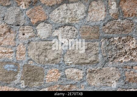 Muro di pietra fatto di grandi mattoni enormi con cemento e cemento. Struttura robusta ad Antalya, Turchia. Sfondo testurizzato con dettagli ravvicinati Foto Stock