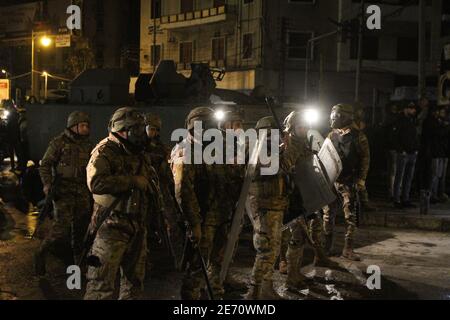 Tripoli, Libano. 29 gennaio 2021. I membri dell'esercito libanese si trovano in una strada a Tripoli, nel nord del Libano, il 29 gennaio 2021. L'esercito libanese ha annunciato venerdì di aver arrestato cinque persone coinvolte nel bruciare la costruzione del comune una notte prima a Tripoli durante violenti scontri di protesta tra cittadini e forze di sicurezza, ha riferito l'Agenzia nazionale delle notizie. Credit: Khaled/Xinhua/Alamy Live News Foto Stock