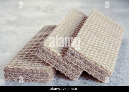 Deliziosi bastoncini di wafer con cioccolato sullo sfondo. Messa a fuoco selettiva. Foto Stock