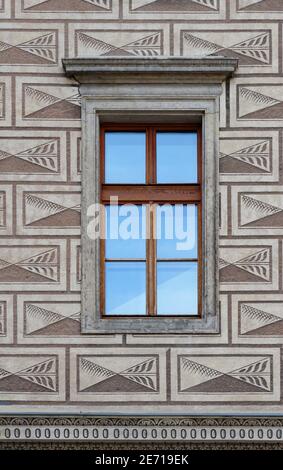 Finestra che riflette il cielo blu sulla parete del Palazzo Schwarzenberg a Praga Foto Stock