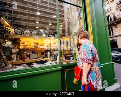 Parigi, Francia - 13 ottobre 2018: Scena parigina di strada con donna femminile guardando la vetrina del negozio che vende diversi accessori da cucina padelle feid pentole e tostapane Foto Stock