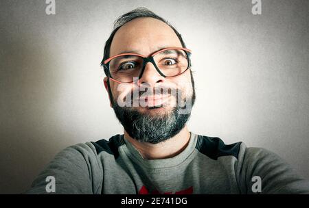 Uomo divertente con la barba che fa espressioni Foto Stock