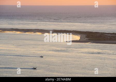 Barche a motore navigano nell'Oceano Atlantico durante un tramonto panoramico vicino al Banc d'Arguin, di fronte alla Dune du Pilat, Pyla sur Mer, Francia Foto Stock