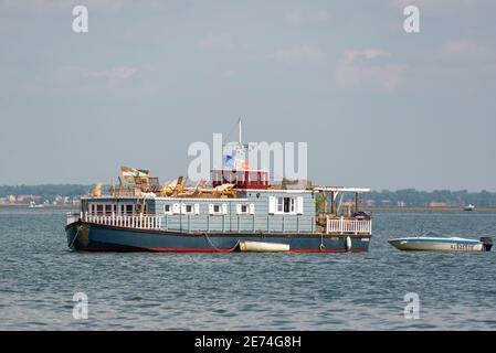 La tradizionale chiatta in legno è a vela nel Bassin d'Arcachon, Gironda, Francia, Europa. La chiatta è dipinta e ha una bandiera francese sulla parte superiore Foto Stock