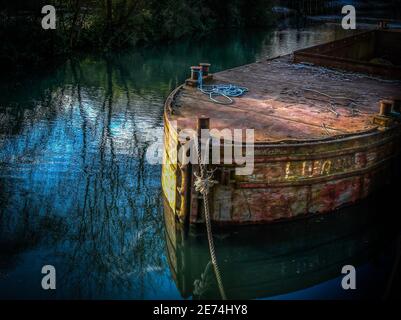 Una vecchia chiatta arrugginita legata sul canale Kennett e Avon a Kintbury, Berkshire Foto Stock