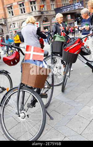 Copenhagen, Danimarca - 4 settembre 2019: Bandiera Dansih attaccata ad una bicicletta con un gruppo di peoole in piedi vicino a fare uno spuntino. Foto Stock