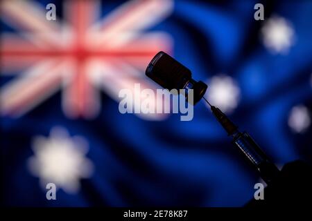 Polonia. 24 gennaio 2021. In questa illustrazione fotografica un flaconcino di vaccino Pfizer-BioNtech COVID-19 e una siringa medica sopra la bandiera australiana. Credit: Vito Corleone/SOPA Images/ZUMA Wire/Alamy Live News Foto Stock