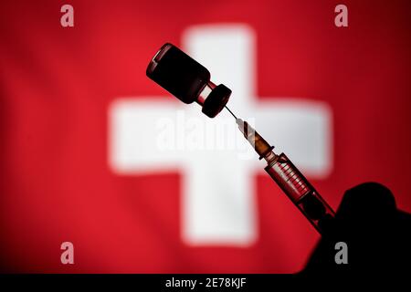 Polonia. 24 gennaio 2021. In questa illustrazione fotografica un flaconcino di vaccino Pfizer-BioNtech COVID-19 e una siringa medica sono visualizzati sopra la bandiera svizzera. Credit: Vito Corleone/SOPA Images/ZUMA Wire/Alamy Live News Foto Stock