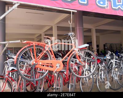 un negozio di biciclette appende una delle sue biciclette rosse tra gli altri per attirare l'attenzione dei potenziali acquirenti Foto Stock