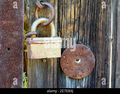 Vecchia porta di legno chiusa sulla serratura arrugginita. Foto Stock