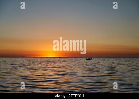 Bel tramonto dorato sul lago titicaca con la sagoma di un pescatore nella sua barca, vicino a copa cabana in Bolivia, Sud America Foto Stock