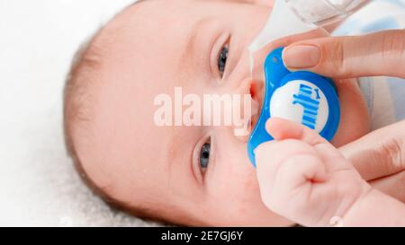 Uso dell'aspiratore nasale per la pulizia del naso del neonato dal muco. Concetto  di igiene e assistenza sanitaria per neonati. Prendersi cura dei genitori  Foto stock - Alamy
