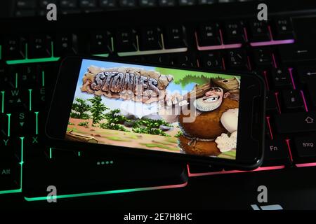 Viersen, Germania - 9 gennaio. 2021: Primo piano dello schermo dello smartphone con la scritta del logo delle lapide dei giochi online sulla tastiera del computer illuminata Foto Stock