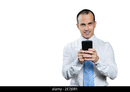 Uomo brasiliano maturo, in abiti formali, cravatta, tenendo smartphone e guardando la fotocamera. Foto Stock