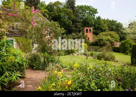 Vista attraverso il prato fino a una torre di follia a Stone Casa Cottage Giardino Foto Stock