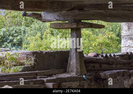 Grande megalito verticale che sostiene una vecchia casa di legno Foto Stock