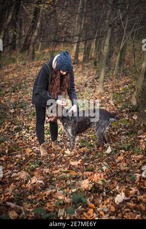 la giovane donna lascia il suo cane da caccia fuori per scout il terreno, alla ricerca di un percorso faunistico. Avviare la ricerca. Donne autentiche con un bel Barbu tchues Foto Stock