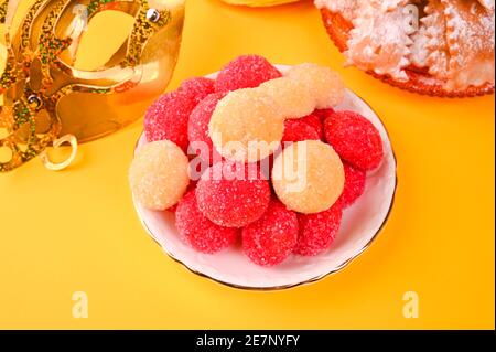 castagnole cotto su sfondo giallo. Dolci tradizionali durante il carnevale in italia. Street food, biscotti rotondi con zucchero per il carnevale di Venezia. Spazio di copia. Foto Stock