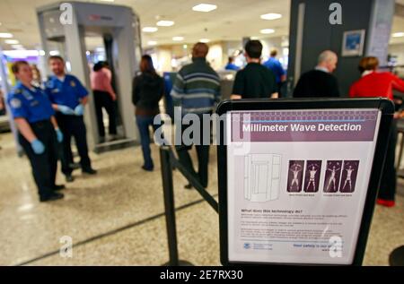A sign explains the procedure for going through the whole body scan machine, or millimeter wave machine as passengers wait in line at  a security check point at the Salt Lake International Airport in Salt Lake City, Utah, March 10, 2009. The new machine developed by New York based L3 Communications is in use for the first time today by passengers and takes a whole body scan penetrating clothing. This is a pilot program by the Transportation Security Administration (TSA)  to test the machines in a live setting. REUTERS/George Frey (UNITED STATES TRANSPORT BUSINESS)