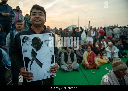 Un protettrice che ha tenuto un ritratto di Mahatma Gandhi durante la dimostrazione.Bhartiya kisan leader sindacale, Rakesh Tikait e agricoltori protestano contro il governo nuove leggi agricole, leader contadini ha osservato un giorno di digiuno in occasione del Mahatma Gandhi morte anniversario. Foto Stock