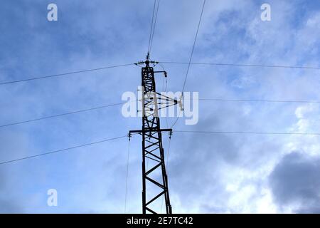 Torre elettrica a media tensione retroilluminata. Cielo blu con nuvole. La Rioja. Foto Stock