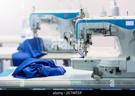 Macchine da cucire, nessuno, industria dei tessuti. Produzione in fabbrica, cucire produzione Abbigliamento tessuto Foto Stock