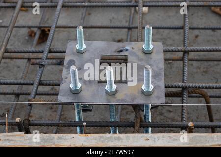 Base per palo luminoso e bulloni di ancoraggio nella base in calcestruzzo. Struttura di base in calcestruzzo con base per palo leggero. Foto Stock