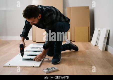 Ritratto di uomo che monta mobili. Fai da te mobili di montaggio. Foto Stock